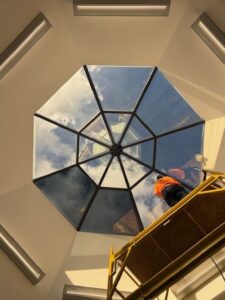 Installer beginning application of 3M Affinity 15 window film to skylight panels at Cleveland Clinic.