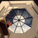 Installer working on partially completed skylight with multiple panels covered in 3M Affinity 15.