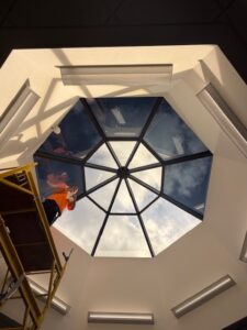 Installer working on partially completed skylight with multiple panels covered in 3M Affinity 15.